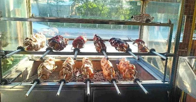 Whole chickens turning on the rotisserie at Tonyo's Litson House